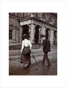 Man and woman crossing the road circa 1900