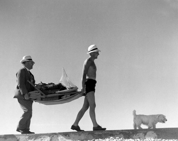 Two men carrying a deckchair, 1920s.