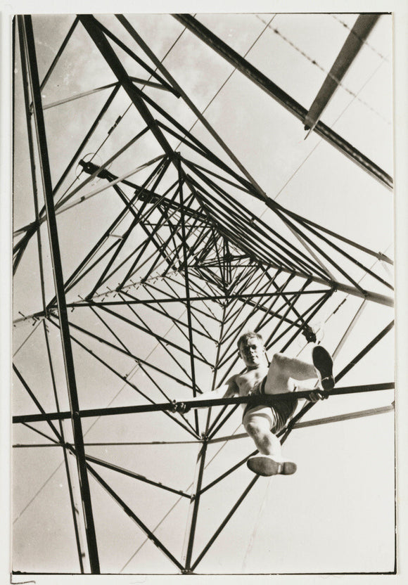 Man climbing a pylon, c 1930.