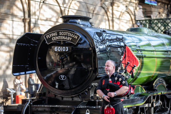 Kevin MacDonald from the Red Hot Chilli Pipers beside Flying Scotsman.