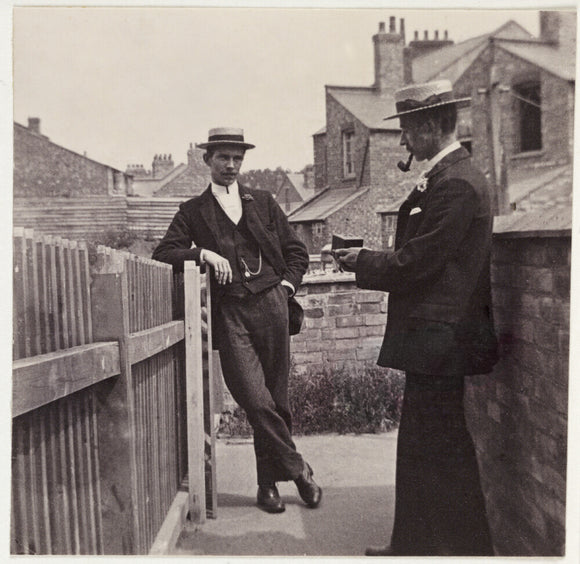 Man taking a photograph with a Brownie camera, c 1900.