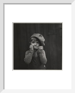 Boy playing the harmonica, about 1925