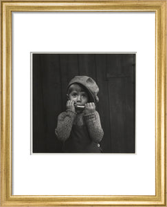 Boy playing the harmonica, about 1925