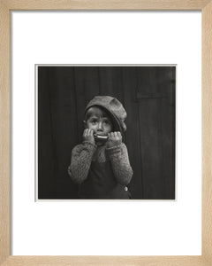 Boy playing the harmonica, about 1925