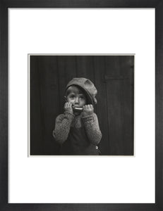 Boy playing the harmonica, about 1925