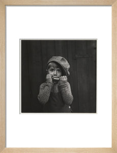 Boy playing the harmonica, about 1925