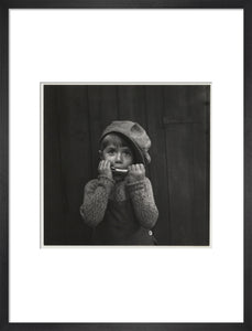 Boy playing the harmonica, about 1925