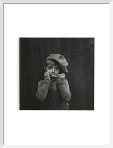 Boy playing the harmonica, about 1925