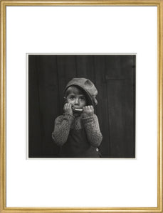 Boy playing the harmonica, about 1925