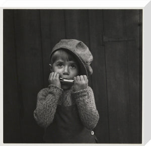 Boy playing the harmonica, about 1925
