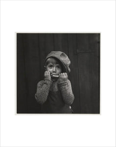 Boy playing the harmonica, about 1925