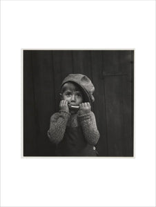 Boy playing the harmonica, about 1925