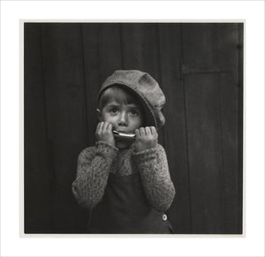 Boy playing the harmonica, about 1925