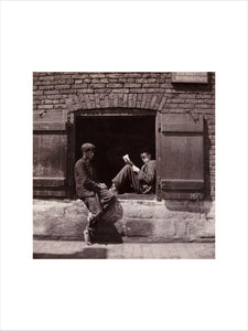 Two boys sitting on a window ledge, c 1905.