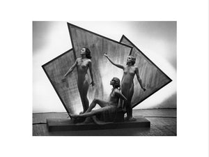 Three near naked women posing on an art deco plinth, c 1920s.