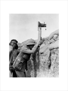 Soldier taking a photograph with a camera attached to a periscope, c 1915.