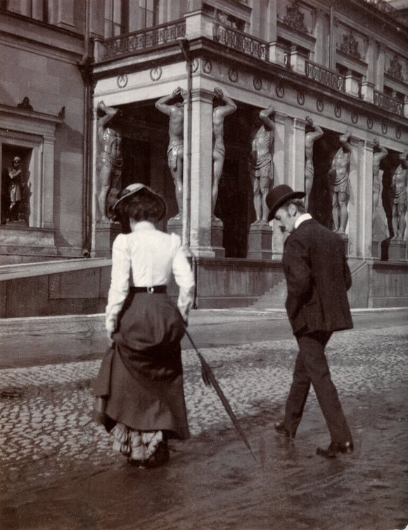 Man and woman crossing the road circa 1900